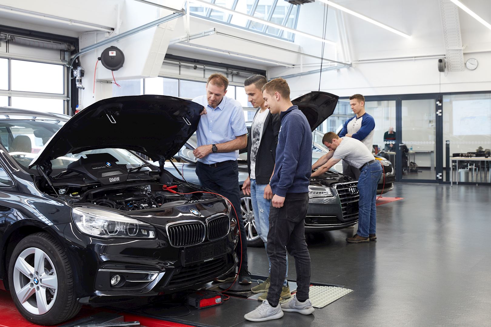 Personen vor Auto in Werkstatt